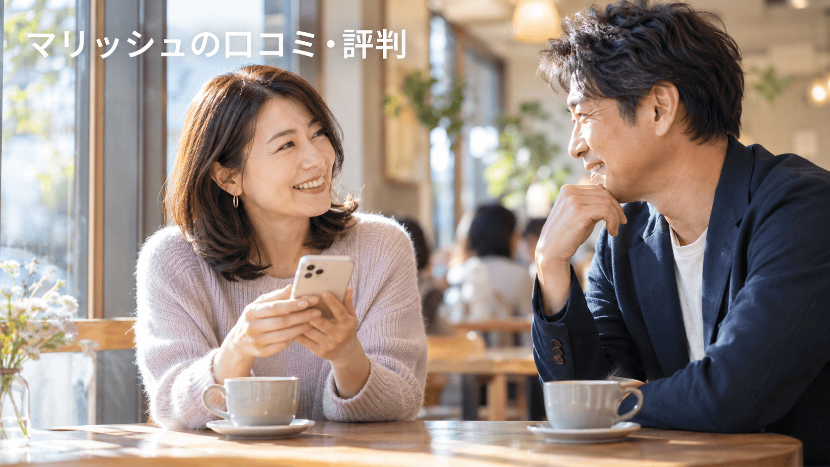 スマートフォンを手にカフェで語り合う40代の男女。マリッシュの口コミ・評判。